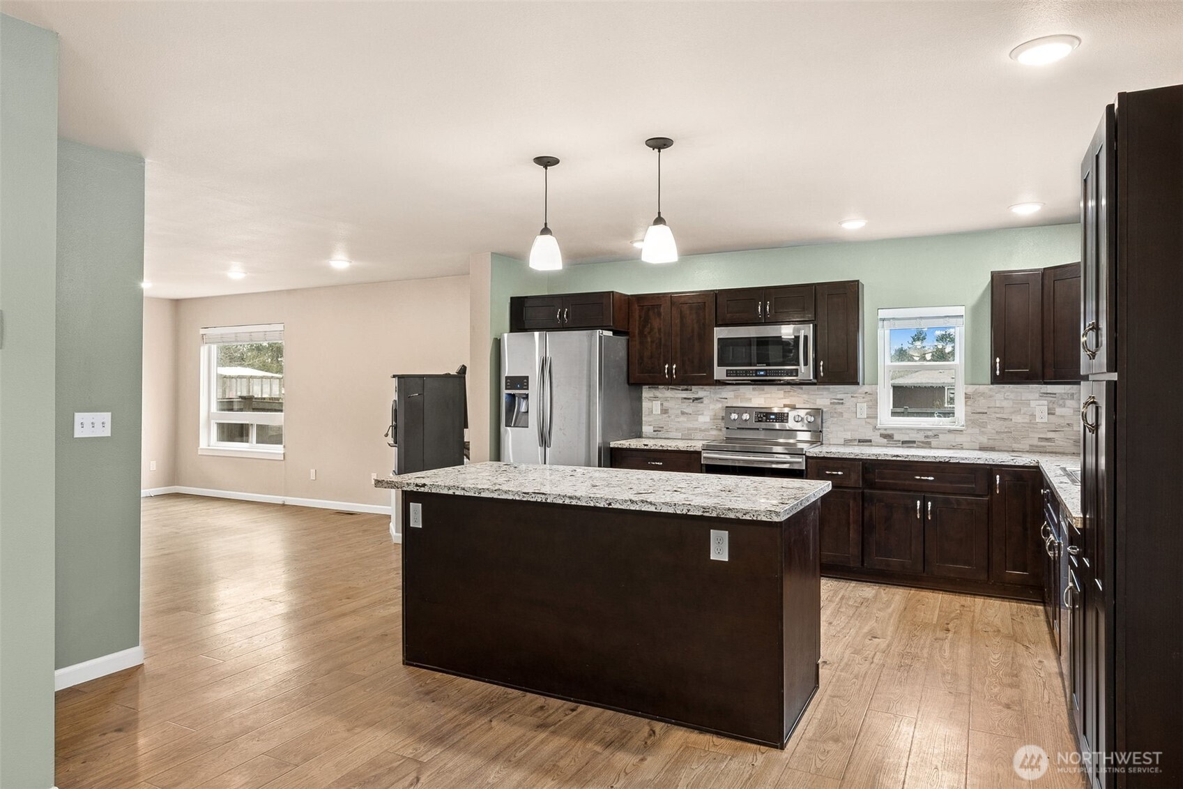 101 Murphy Lane South Rainier, WA 98576 - Photo 9 of 40 a kitchen with stainless steel appliances granite countertop a stove top oven a sink dishwasher a refrigerator and a dining table with wooden floor