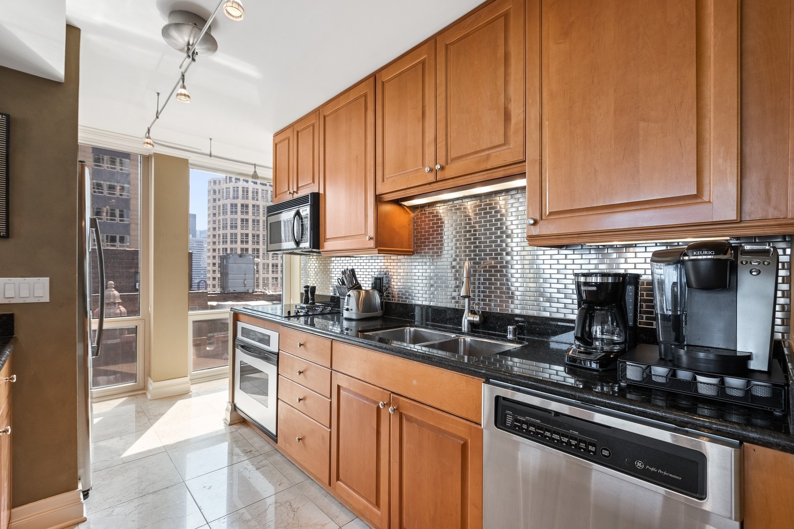 111 East Chestnut Street, Unit 25K Chicago, IL 60611 - Photo 11 of 28 a kitchen with stainless steel appliances granite countertop a sink stove refrigerator and cabinets