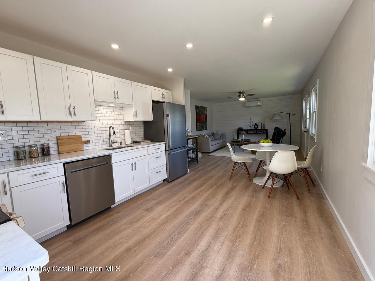 7 Park Circle High Falls, NY 12440 - Photo 11 of 31 a living room with stainless steel appliances kitchen island granite countertop a sink dishwasher a stove a refrigerator and cabinets with wooden floor