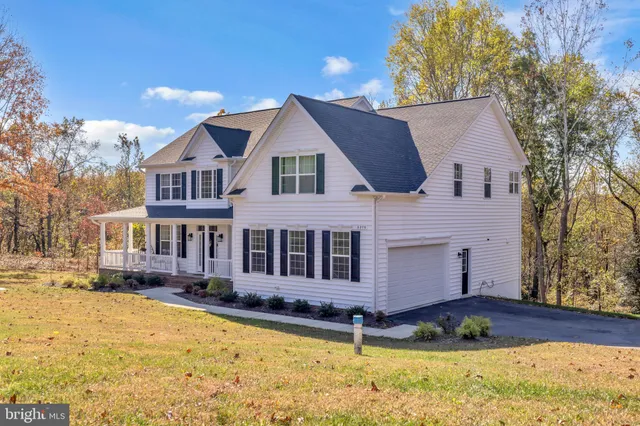 a view of a house with a big yard and large trees