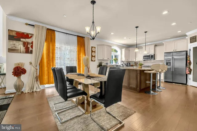 a view of a dining room and livingroom with furniture wooden floor a chandelier