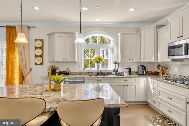 a kitchen with stainless steel appliances granite countertop a refrigerator a stove a sink a counter space and cabinets