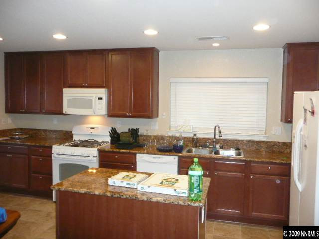 9010 Yeager Street Reno, NV 89506 - Photo 4 of 9 a kitchen with granite countertop sink cabinets and stainless steel appliances