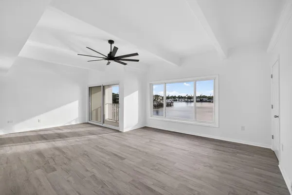 a view of a livingroom with wooden floor and a ceiling fan
