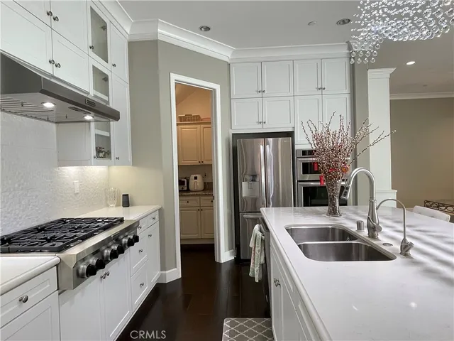 a kitchen that has a sink a refrigerator and cabinets