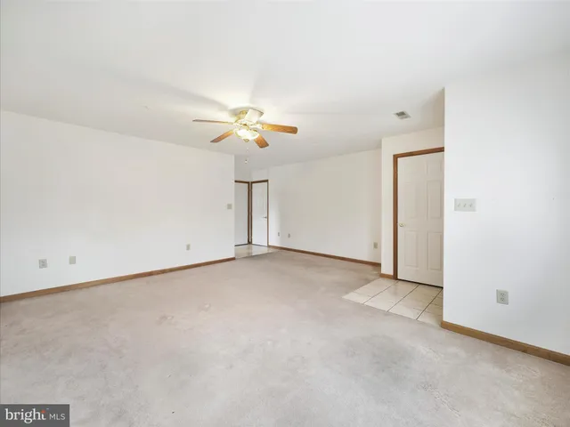 an empty room with a ceiling fan and a window