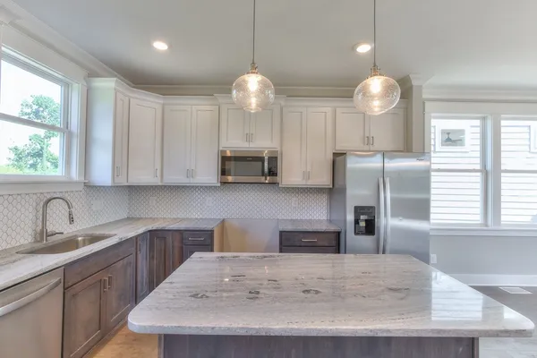 a kitchen with stainless steel appliances granite countertop a sink a stove and a refrigerator