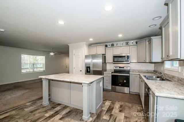 a view of a house with a yard and large tree