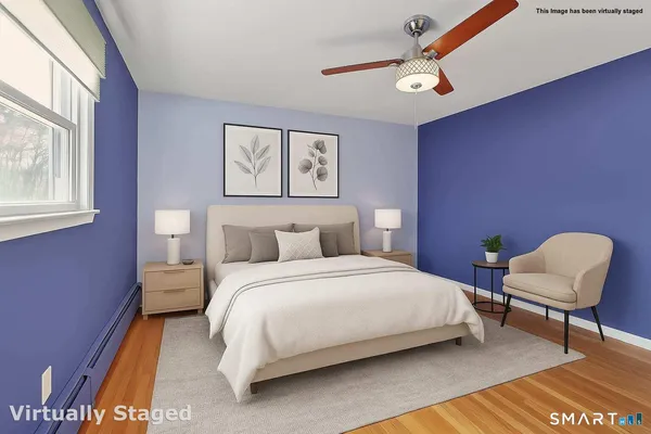 a bedroom with a bed a chair and a large window