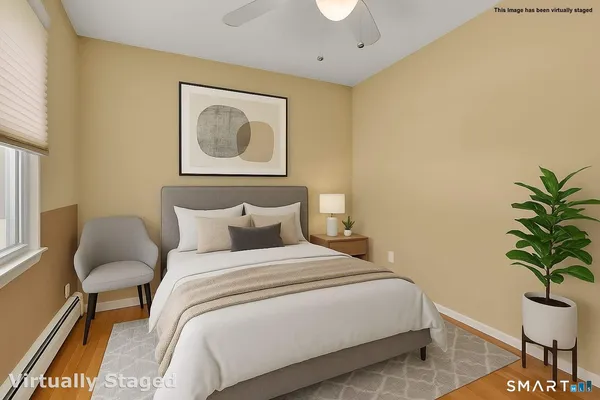 a bedroom with bed and a potted plant