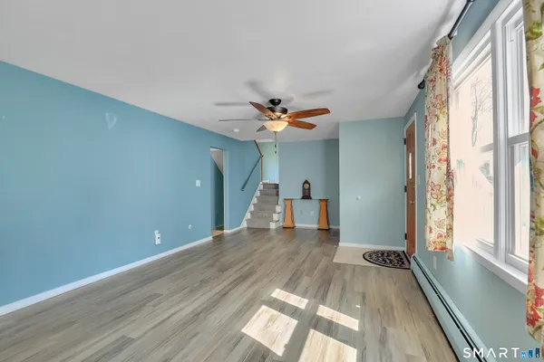 a view of a room with a ceiling fan and window