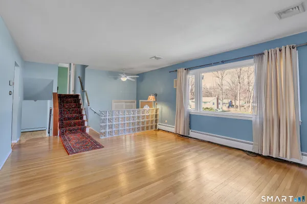 an empty room with wooden floor and windows