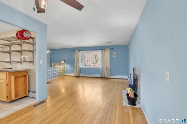 a view of an empty room with window and wooden floor