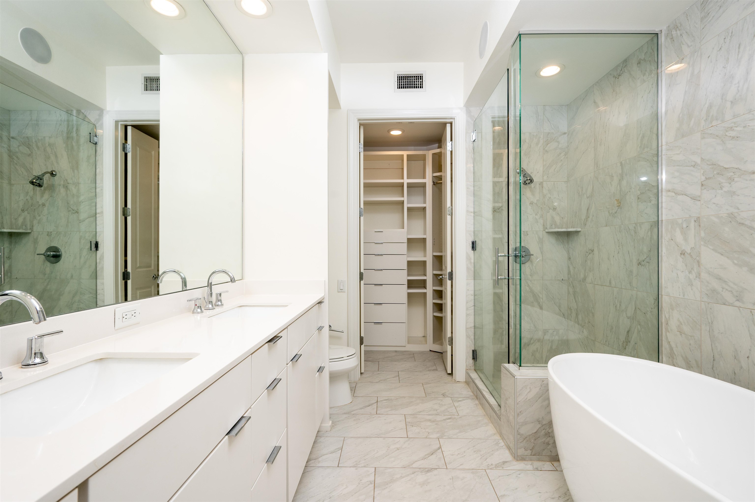 717 Riverside Drive, Unit 1506 Memphis, TN 38103 - Photo 32 of 38 Bathroom with double vanity, a freestanding tub, a shower stall, light marble finish flooring, and recessed lighting