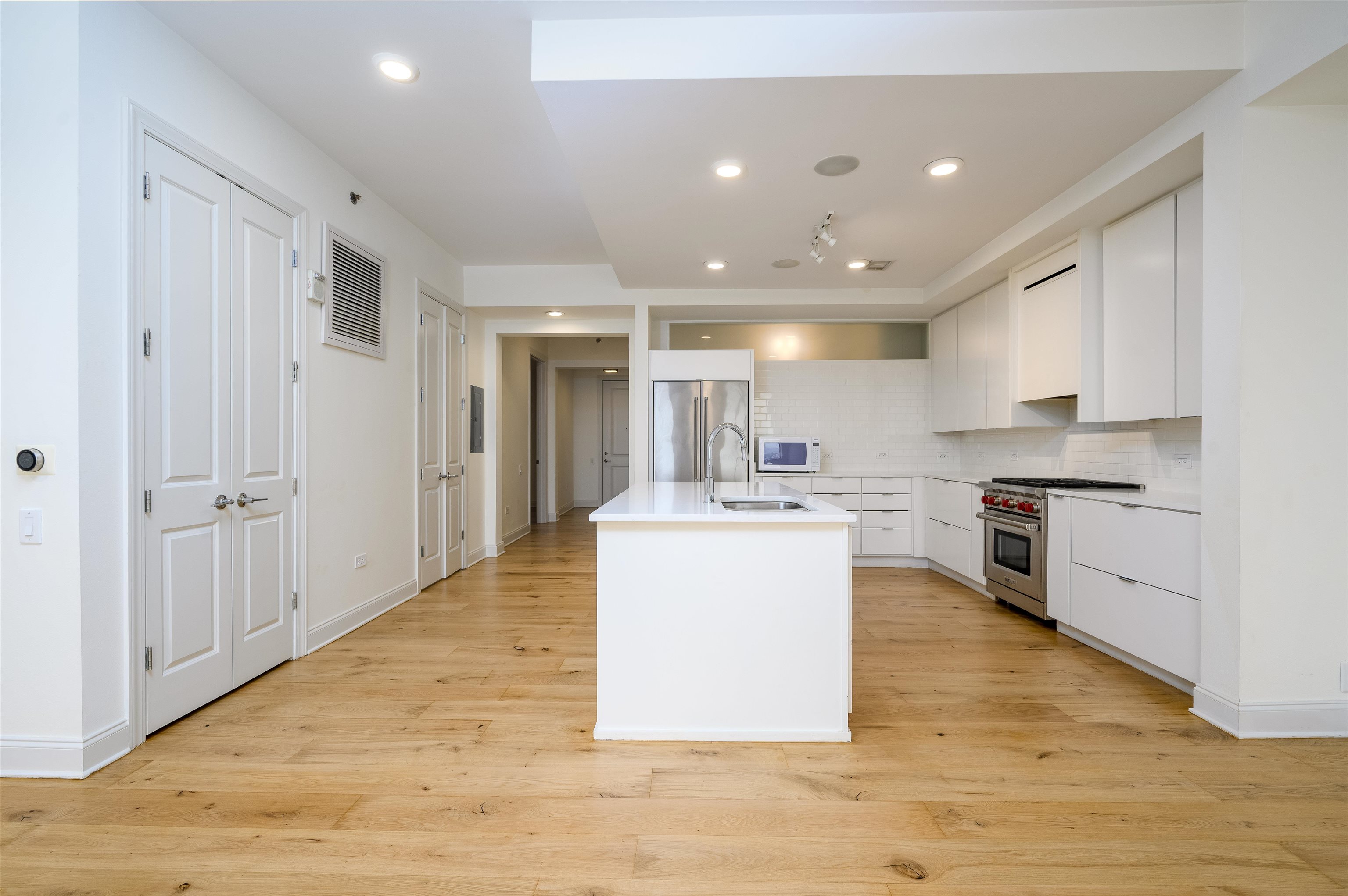 717 Riverside Drive, Unit 1506 Memphis, TN 38103 - Photo 5 of 38 a kitchen with kitchen island sink stove and white cabinets