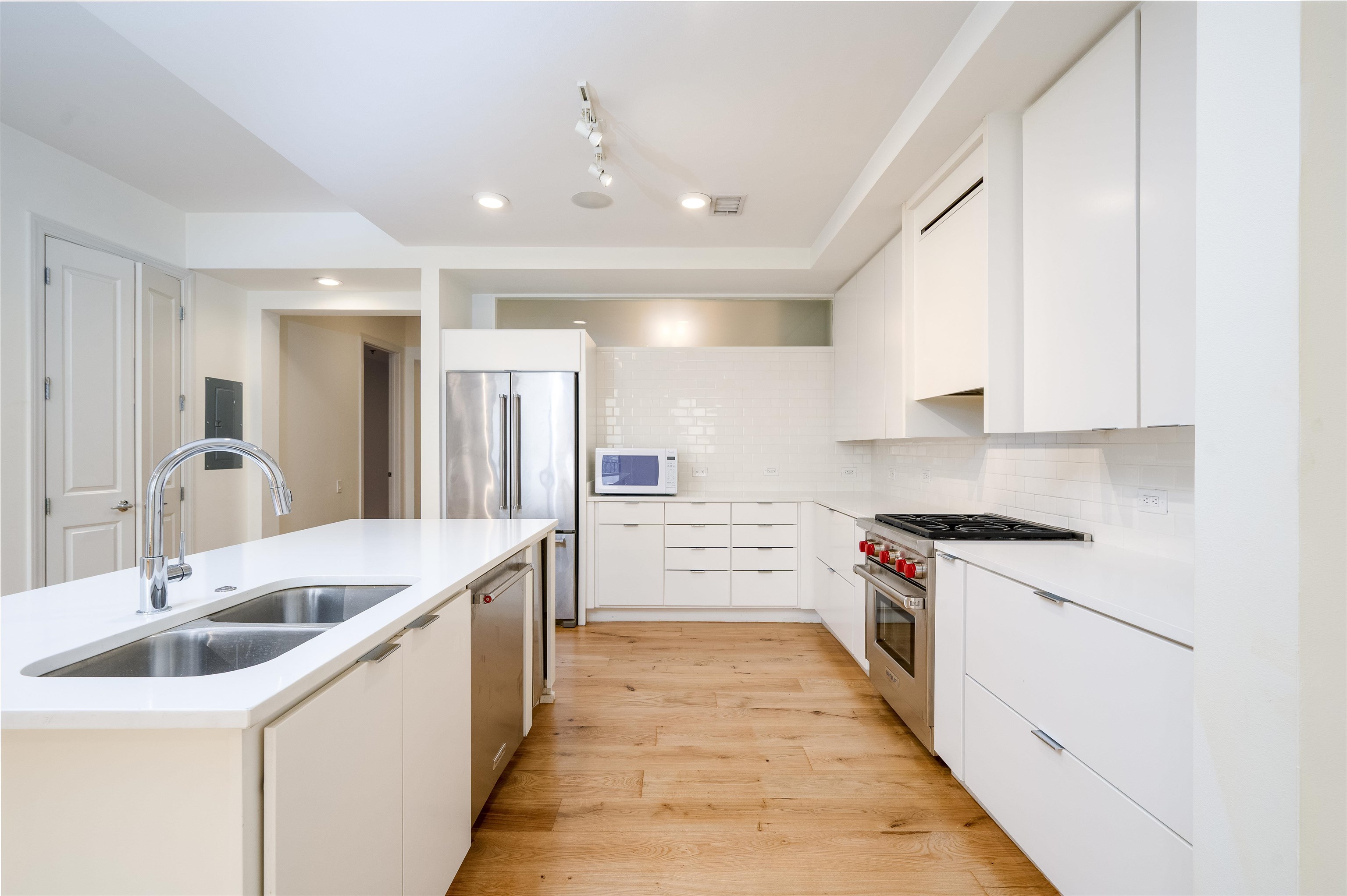 717 Riverside Drive, Unit 1506 Memphis, TN 38103 - Photo 6 of 38 a large white kitchen with stainless steel appliances granite countertop a sink and dishwasher a stove with wooden floor