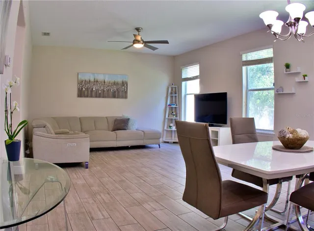 a living room with furniture a chandelier and a flat screen tv