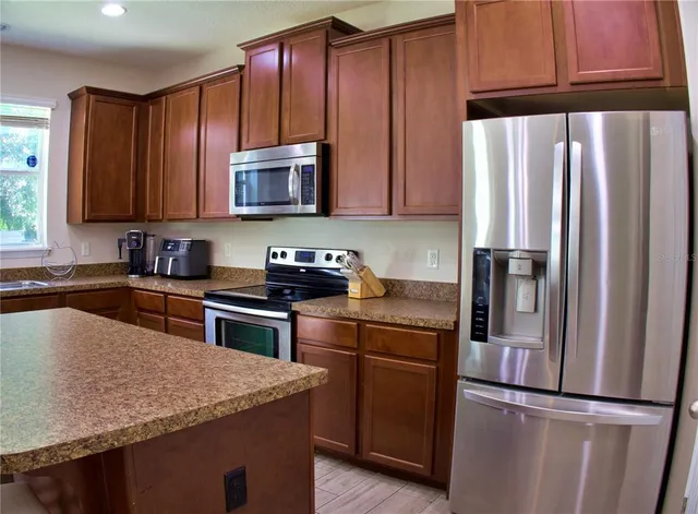 a kitchen with granite countertop wooden cabinets and stainless steel appliances