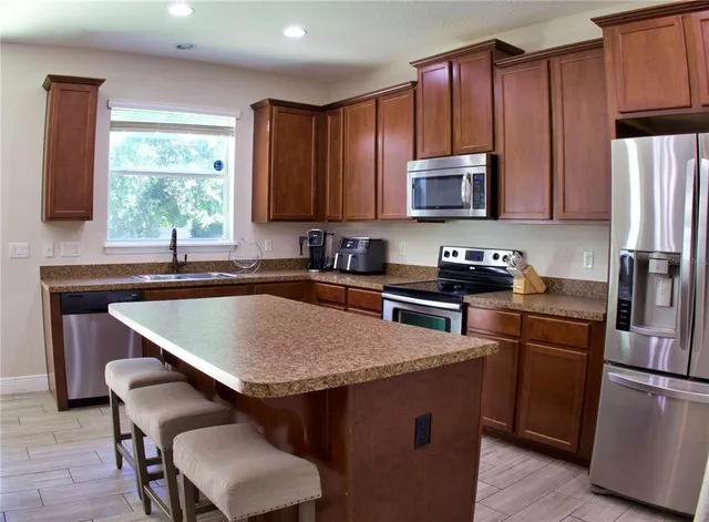 a kitchen with kitchen island a sink table and chairs