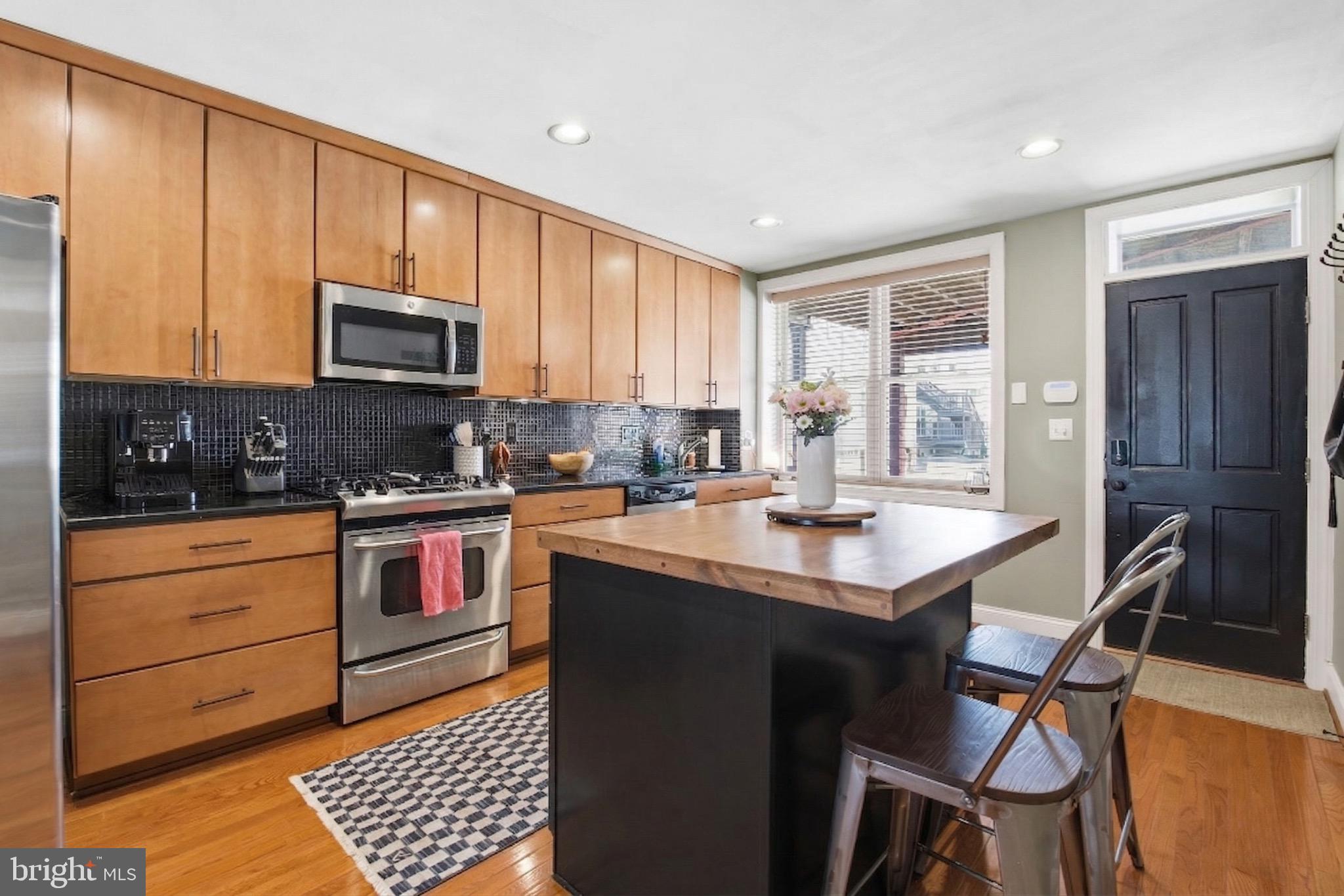 3312 Fleet Street Baltimore, MD 21224 - Photo 7 of 26 a kitchen with stainless steel appliances granite countertop a stove a sink dishwasher and a refrigerator with wooden cabinets