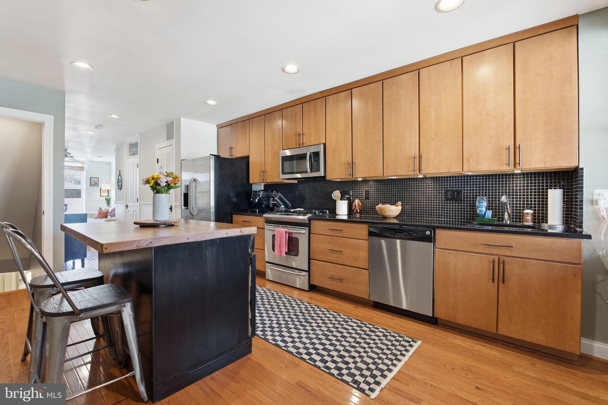 3312 Fleet Street Baltimore, MD 21224 - Photo 10 of 26 a kitchen with stainless steel appliances granite countertop a stove a sink a microwave a refrigerator and cabinets