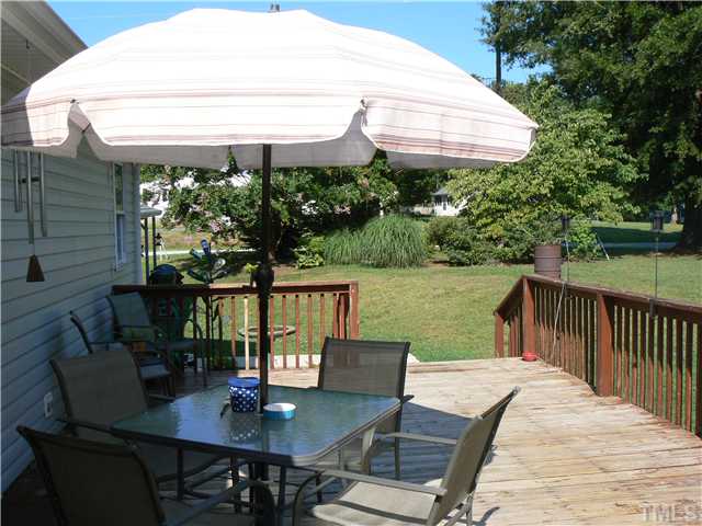 1723 Bahama Road Bahama, NC 27503 - Photo 4 of 14 a view of a patio with table and chairs under an umbrella with a small yard