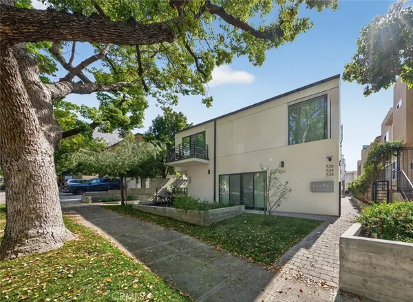 a view of a yard with plants and a fountain