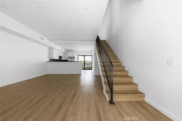 a kitchen with stainless steel appliances granite countertop a refrigerator a stove a sink and a large window