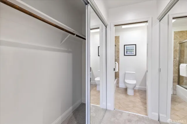 a bedroom with a bed and a lamp on dresser