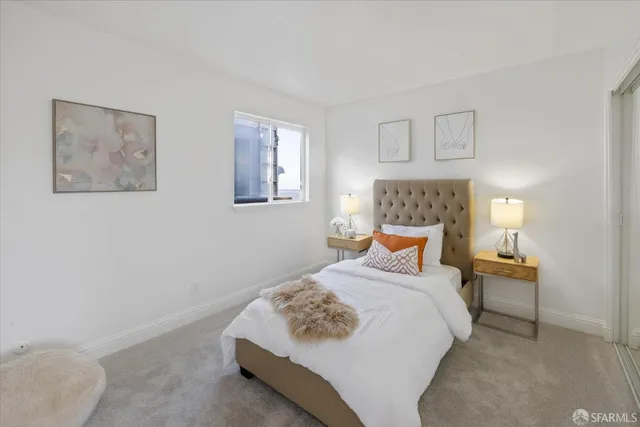 a bedroom with a bed chandelier and a window