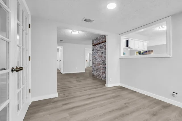 a view of empty room with wooden floor