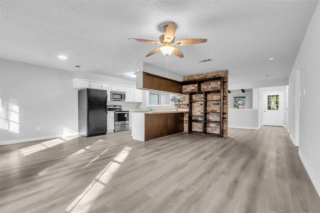 a view of a livingroom with hardwood floor and a ceiling fan