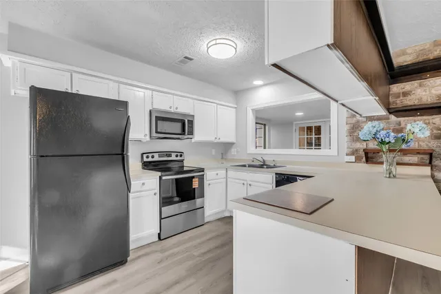 a kitchen with a refrigerator and a stove top oven
