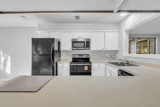 a kitchen with stainless steel appliances a refrigerator stove microwave and sink