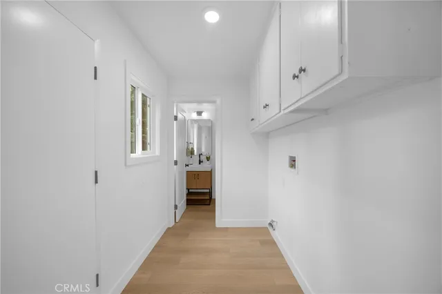 a view of a hallway with bathroom and a sink