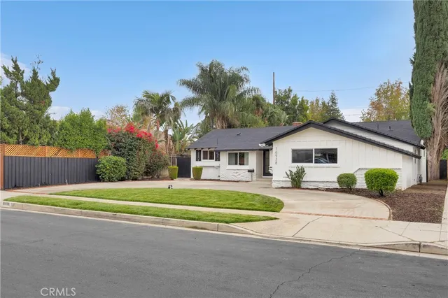 a front view of a house with a yard and trees