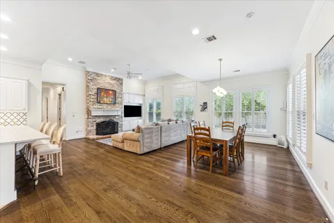 a living room with fireplace furniture dining table and a large window
