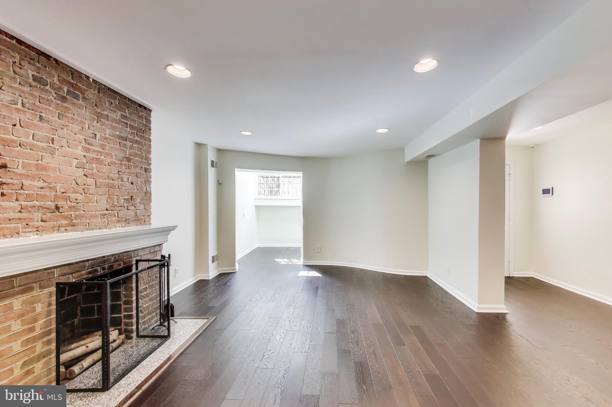 1625 S Street Northwest, Unit 1 Washington, DC 20009 - Photo 5 of 13 an empty room with wooden floor fireplace and windows