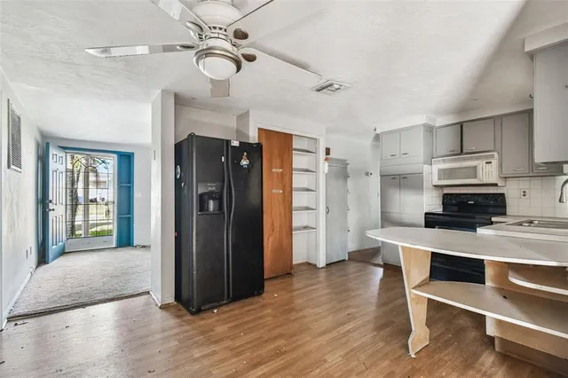 a kitchen with granite countertop a stove microwave and sink