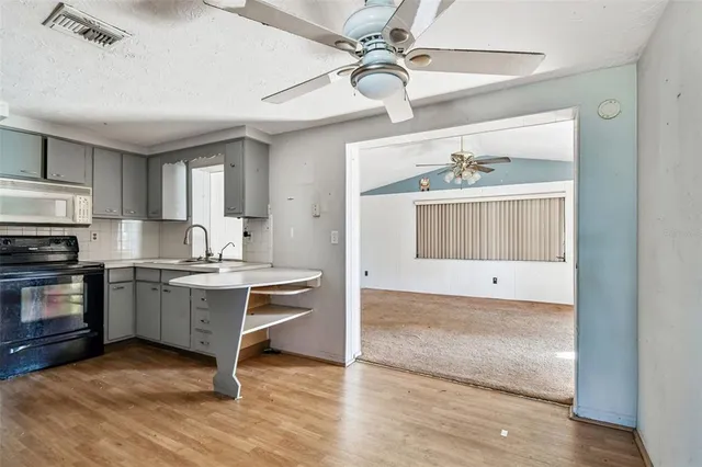 a kitchen with kitchen island granite countertop a sink cabinets and stainless steel appliances
