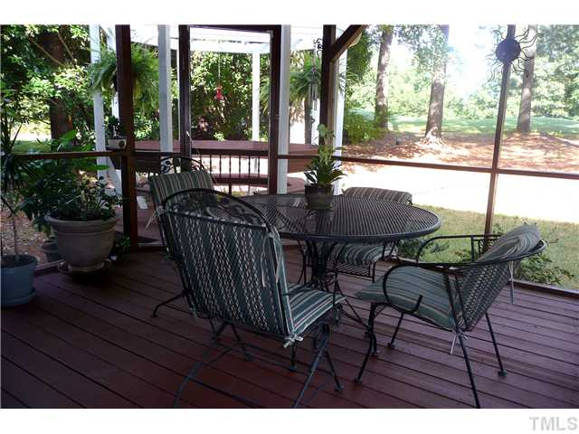 5116 Salem Ridge Road Holly Springs, NC 27540 - Photo 5 of 25 Whether you are enjoying a casual dinner or sipping that first cup of coffee in the morning, the screened porch will be a favorite of yours in this home. Just beyond the trees is the 7th green of Devil's Ridge Golf Course. Screened Porch