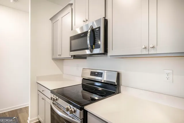 a kitchen with stainless steel appliances a stove microwave and sink