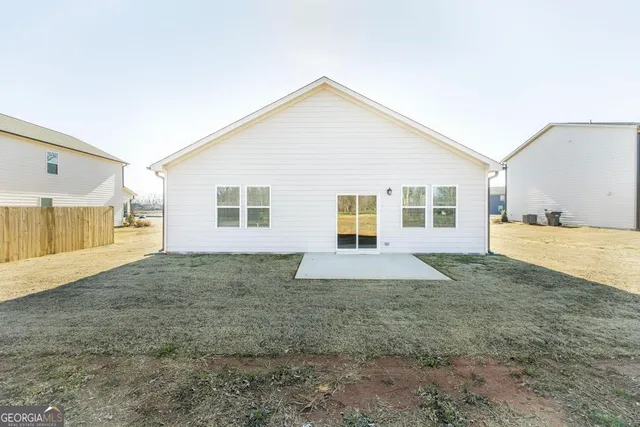 a view of a house with backyard and trees