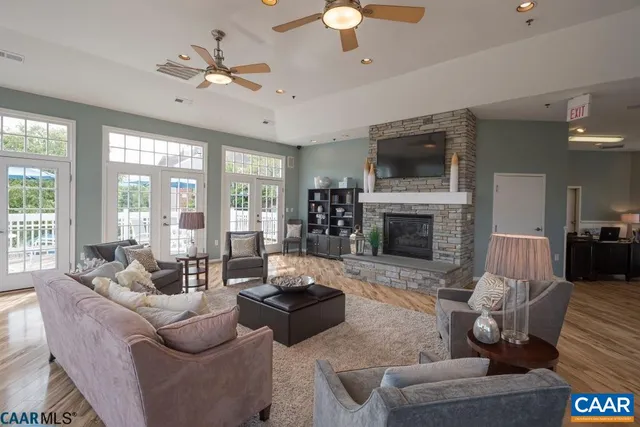 a dining room with wooden floor a chandelier fan a wooden table and chairs
