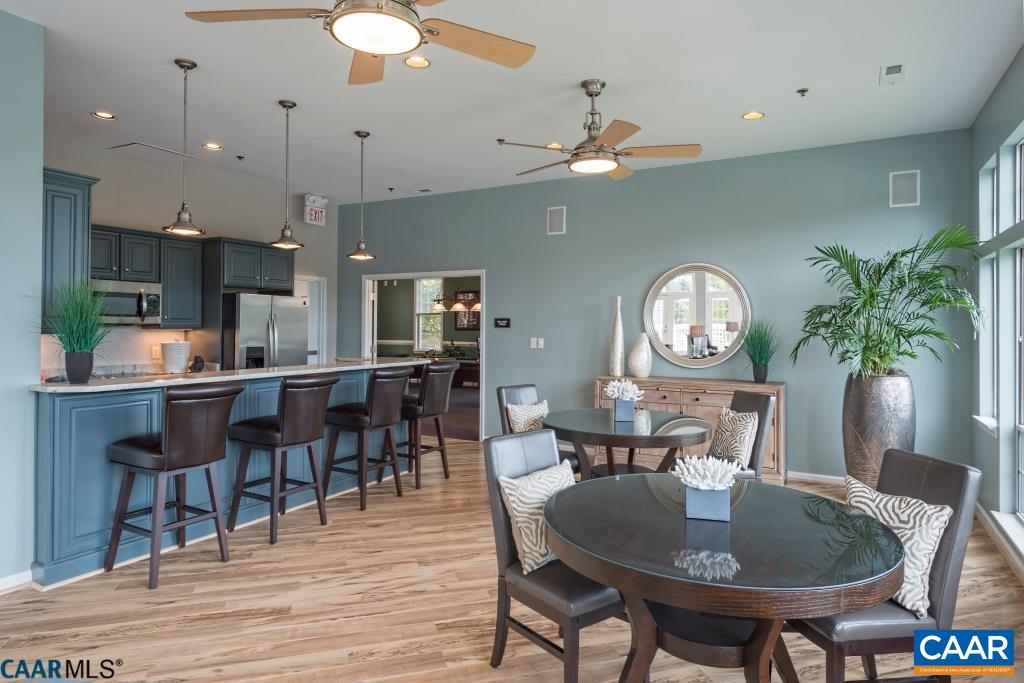200 Lake Club Court Charlottesville, VA 22902 - Photo 16 of 17 a dining room with wooden floor a chandelier fan a wooden table and chairs