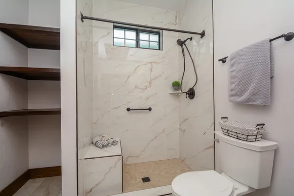 a bathroom with a toilet and a shower