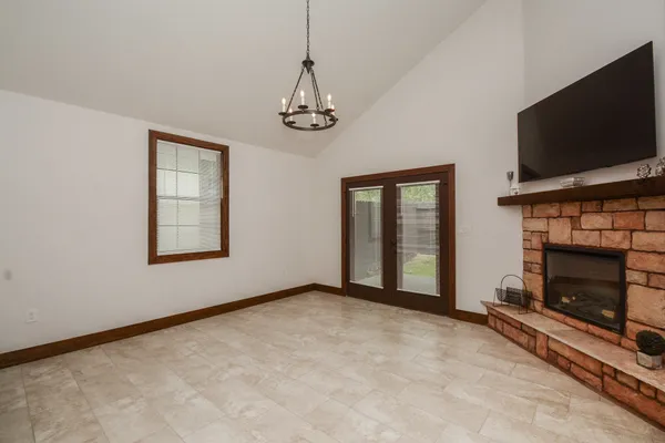 a view of an empty room with window and fireplace