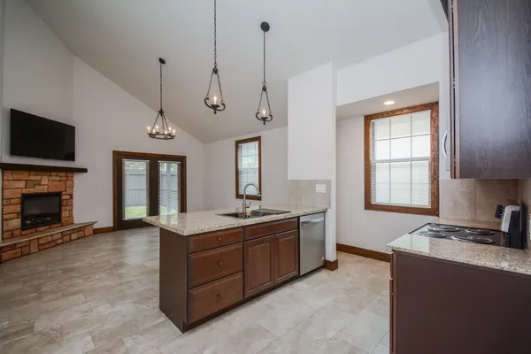 a view of a kitchen with a sink a window and a fireplace