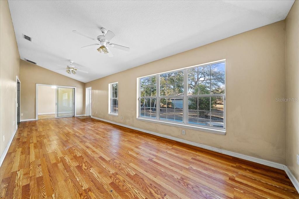 10308 Southwest 83rd Terrace Ocala, FL 34481 - Photo 44 of 75 a view of empty room with wooden floor and fan