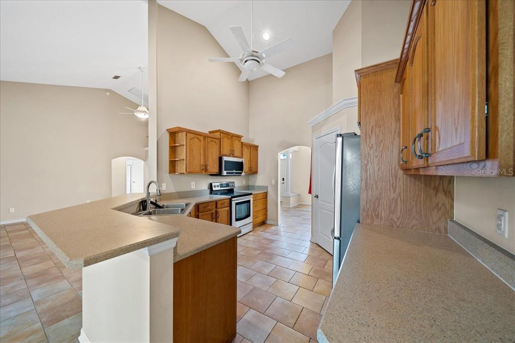 10308 Southwest 83rd Terrace Ocala, FL 34481 - Photo 49 of 75 a kitchen with stainless steel appliances a stove refrigerator sink and cabinets